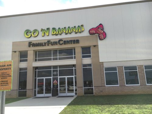 Exterior of "Go 'N Bananas Family Fun Center" building with colorful signage and a grassy area in front.