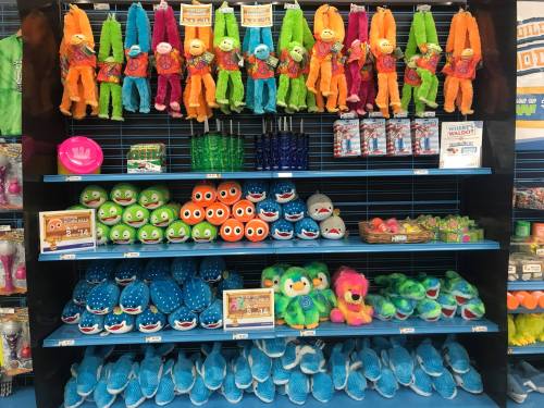 A colorful display of plush toys and accessories, featuring various characters in bright colors on shelves.