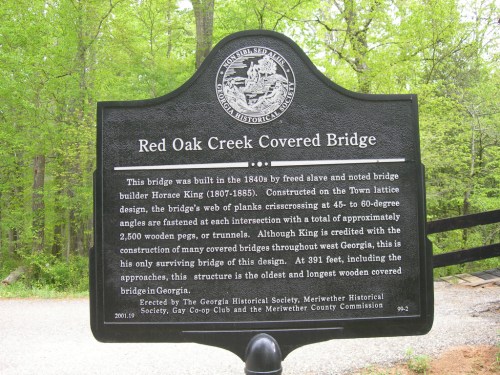 Sign about the Red Oak Creek Covered Bridge, detailing its history and construction by builder Horse King in the 1840s.