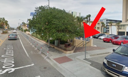 A street view showing a tree and parked cars, with a red arrow pointing to a nearby area on South Ocean Boulevard.