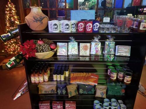 A display shelf filled with various decorative items, snacks, and drinks, adorned with holiday decorations.