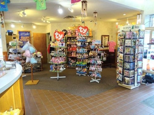 A colorful gift shop interior featuring plush toys, greeting cards, and a welcoming display area.