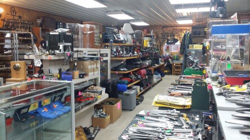 A cluttered tool shop filled with various tools, shelves, and equipment, showcasing a wide range of hardware items.