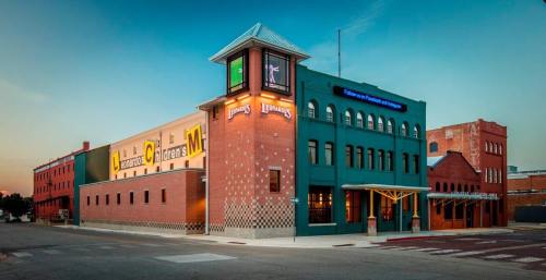 A colorful building with a tower, featuring signage and a modern design, set against a sunset sky.
