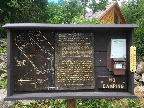 Signboard at Crawford Notch State Park with a trail map, safety information, and a "No Camping" notice.