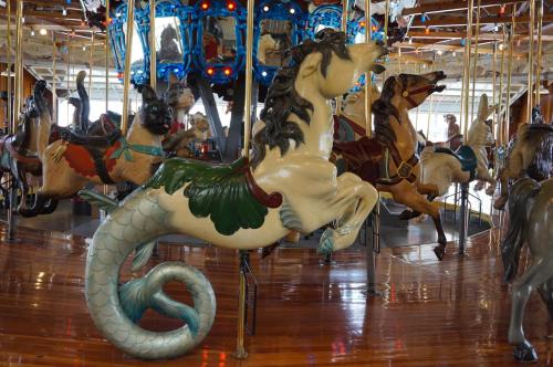 A whimsical carousel featuring a mermaid-themed horse among other ornate carousel animals.