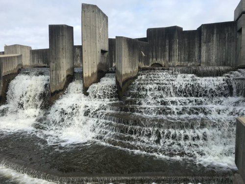 A concrete structure with cascading water flowing over multiple tiers, creating a serene waterfall effect.