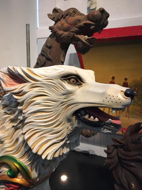 A detailed wooden carving of a wolf's head, showcasing intricate features and a fierce expression.
