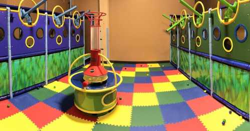 Colorful indoor play area with soft flooring, climbing structures, and various interactive features for children.