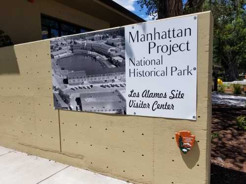 Sign for the Manhattan Project National Historical Park at the Los Alamos Site Visitor Center, featuring a historic photo.