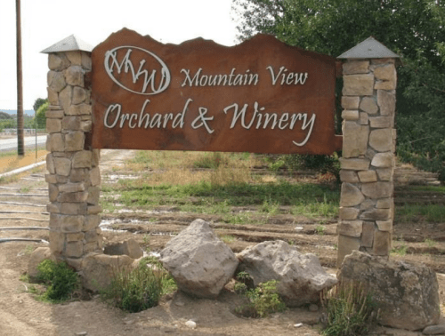Sign for Mountain View Orchard & Winery, featuring stone pillars and a rustic design, set in a rural landscape.