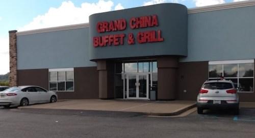 Exterior of Grand China Buffet & Grill, featuring a large sign and parked cars in front of the building.