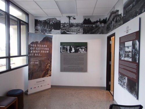 Interior view of a room featuring historical photos, informational panels, and a banner celebrating 100 years of outdoor experiences.