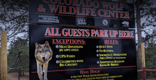 Sign at Colorado Wolf & Wildlife Center detailing parking rules, exceptions, and safety guidelines for visitors.