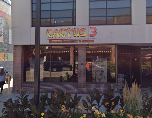 Exterior of Cactus 3, a Mexican restaurant and cantina, featuring a colorful sign and flower beds in front.