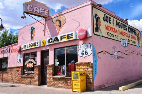 Colorful exterior of Joe & Aggie's Cafe, featuring Route 66 signage and murals, showcasing Mexican-American cuisine.