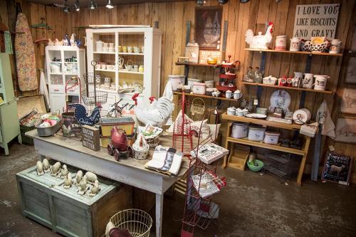 A cozy vintage shop filled with rustic decor, kitchenware, and charming farm-themed items on wooden shelves.