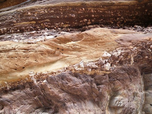 Layered rock formations showcasing various colors and textures, highlighting geological features and erosion patterns.