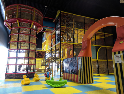 Colorful indoor play structure with slides, climbing areas, and soft play equipment for children.