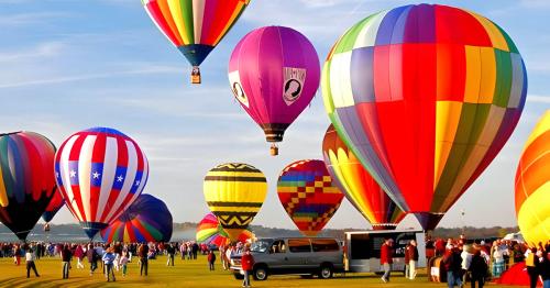 A vibrant scene of colorful hot air balloons in the sky, with a crowd gathered on the ground below.