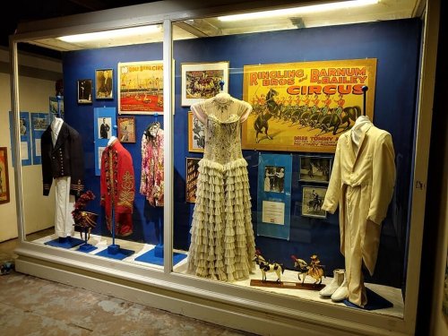 Display case featuring vintage circus costumes, posters, and memorabilia from Ringling Bros. and Barnum & Bailey Circus.