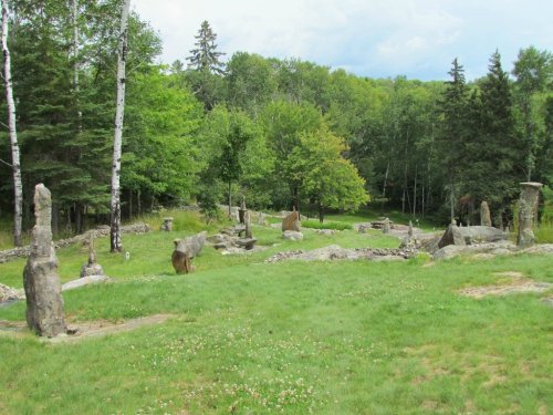 A grassy area with standing stones and trees, creating a serene, natural landscape.