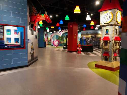 Colorful indoor play area featuring whimsical decorations, including a dragon, clock tower, and various play zones.