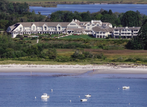 A scenic view of a coastal resort with boats in the water and lush greenery surrounding the property.