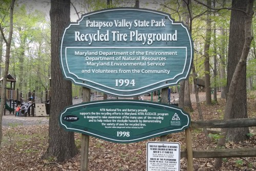 Sign at Patapsco Valley State Park for a recycled tire playground, highlighting community and environmental efforts. Established 1994.