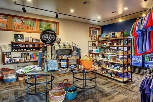 A cozy shop interior featuring shelves of various goods, including clothing, home items, and colorful baskets.