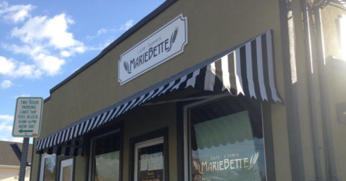 Exterior of MarieBette Café & Bakery, featuring a striped awning and a sign above the entrance.