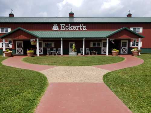 A red barn-style building with a green roof, featuring a welcoming entrance and landscaped pathways.