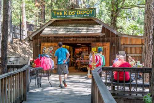 A wooden store entrance labeled "The Kids' Depot," with colorful clothing displayed outside and visitors walking in.