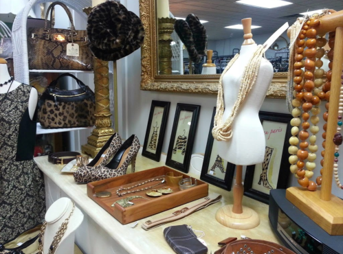 A display of stylish accessories, including jewelry, shoes, and handbags, in a chic boutique setting.