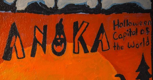 An orange and black mural reads "Anoka Halloween Capital of the World" in hand-painted letters.