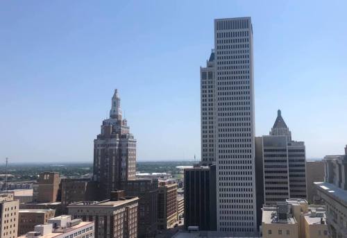 A city skyline featuring tall buildings under a clear blue sky.