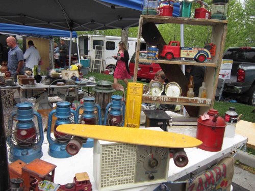 A vibrant flea market scene featuring vintage items, including lanterns, a yellow skateboard, and retro toys on display.