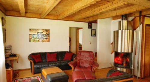Cozy living room with wooden beams, leather sofas, a fireplace, and warm decor.