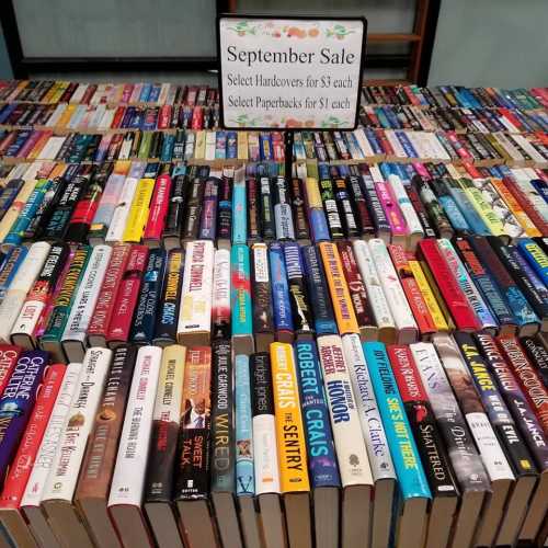 A display of books for a September sale, featuring hardcovers for $3 and paperbacks for $1 each.