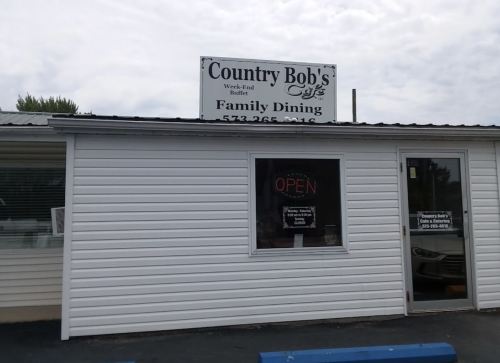 Exterior of Country Bob's Cafe, featuring a sign for family dining and an "OPEN" notice in the window.