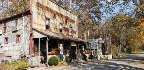 A rustic, weathered building with a sign reading "Standard Service," surrounded by autumn foliage and pumpkins.