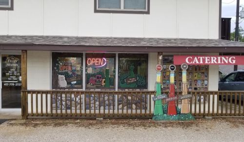 A storefront with "OPEN" sign, colorful decorations, and a "CATERING" sign on the right side.