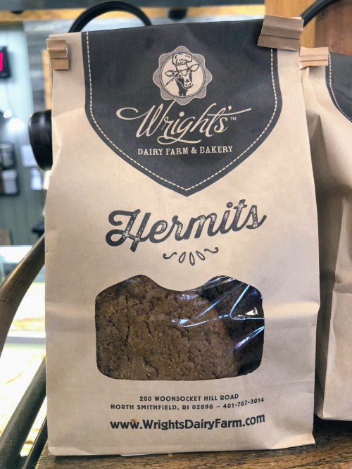 A paper bag labeled "Hermits" from Wright's Dairy Farm & Bakery, featuring a logo and contact information.