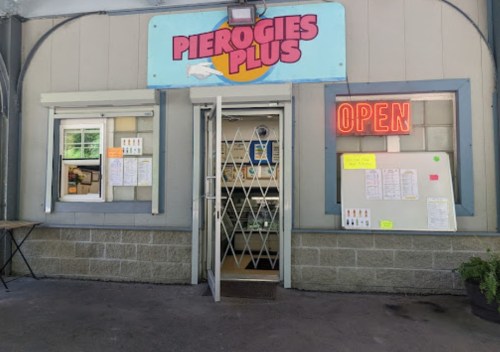 Exterior of Pierogies Plus with an open sign, featuring a menu board and a welcoming entrance.