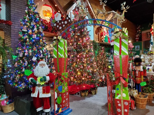 A festive scene with decorated Christmas trees, colorful ornaments, Santa Claus, and nutcracker figures.