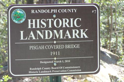 Sign marking the Pisgah Covered Bridge as a historic landmark in Randolph County, established in 1911.