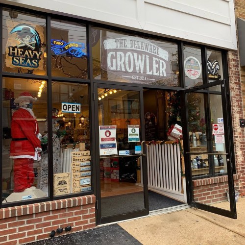 Entrance of The Delaware Growler store, featuring festive decorations and an open sign.