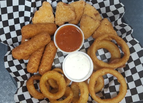 A platter of fried snacks including onion rings, mozzarella sticks, and chicken nuggets with dipping sauces.