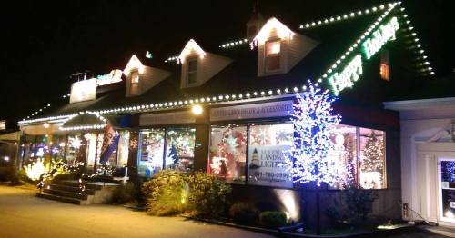 A festive store decorated with colorful lights and holiday displays, glowing warmly at night.
