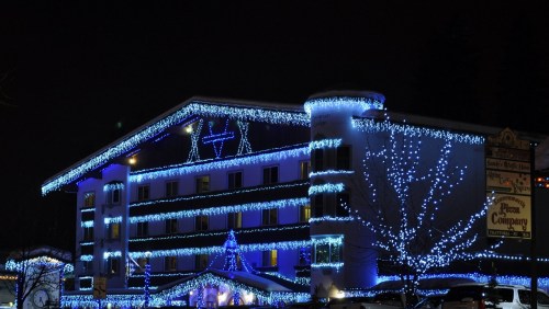 A hotel decorated with blue and white lights for the holiday season, glowing against a dark night sky.